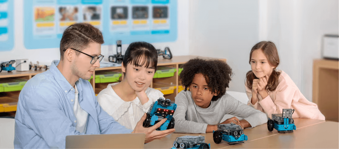 Educators and students engaging with Makeblock robotics kits in a classroom setting.