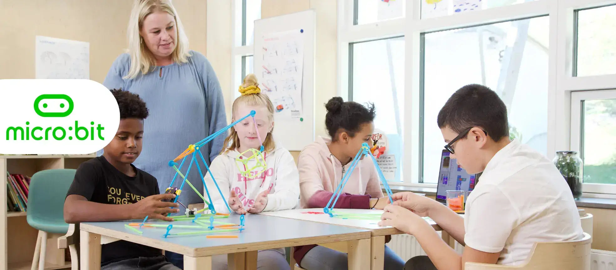 Students engaged in hands-on coding activities with Micro:bit and Strawbees in a classroom setting.