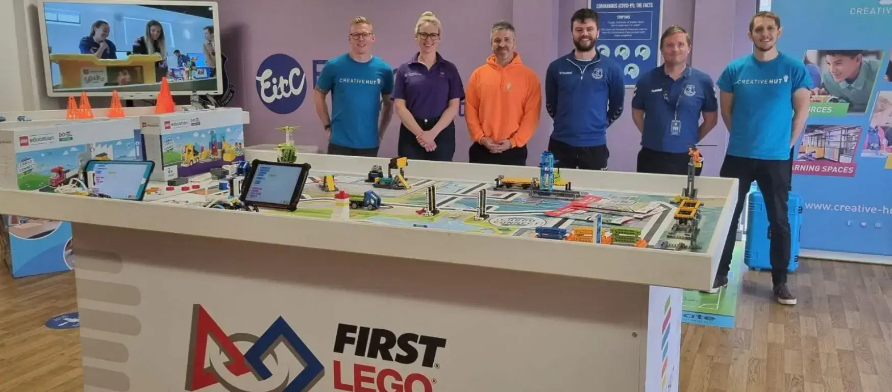 Group of educators at the FIRST LEGO workshop in Liverpool, showcasing robotics and community engagement activities.