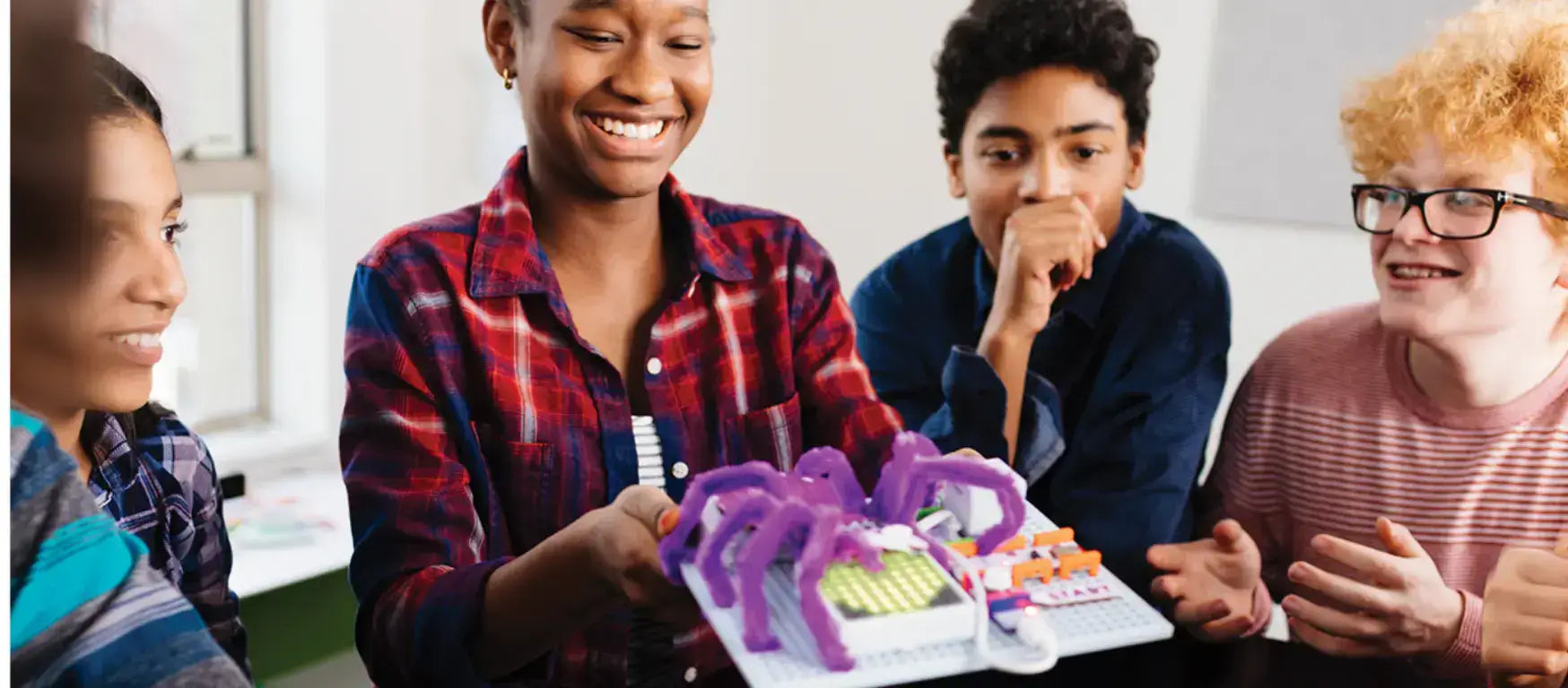 Group of kids enjoying LittleBits electronic building blocks, showcasing a creative circuit project.