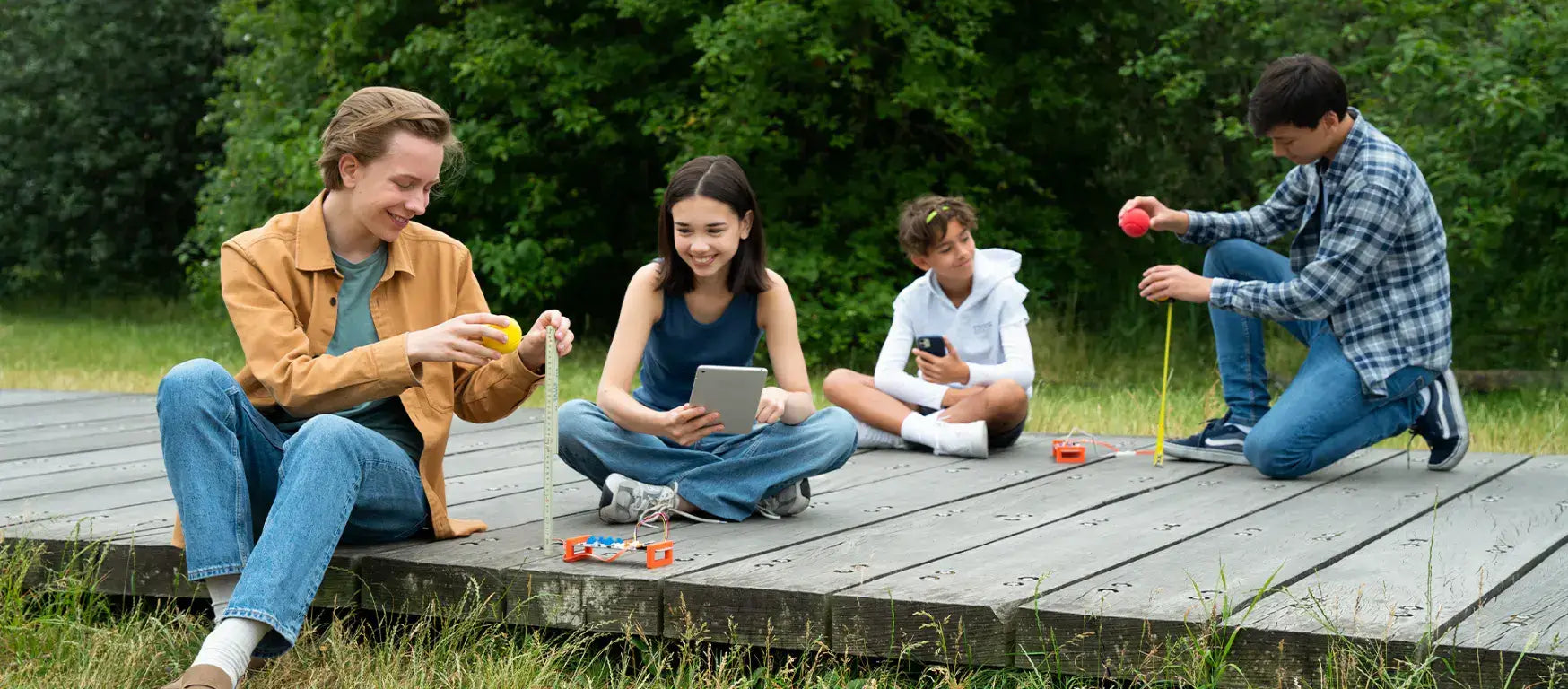Students engaged in hands-on STEM activities outdoors with Arduino Science Kit R3, promoting interactive physics learning.