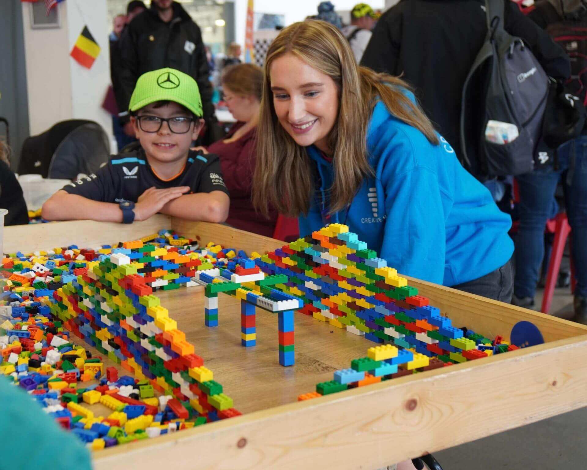 Kids engaged in creative play with colorful building blocks at a fun LEGO event.