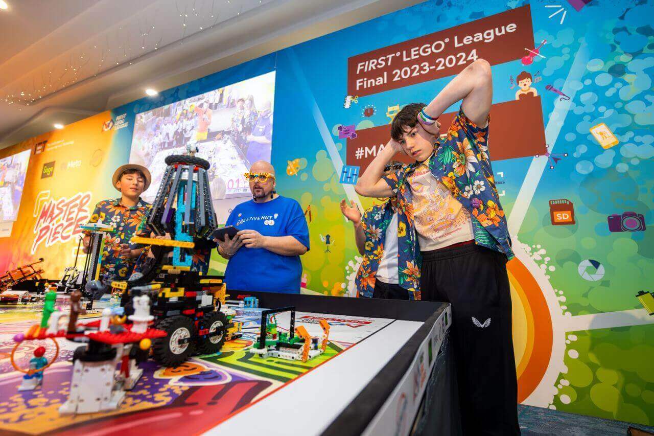 Team members and spectators at the FIRST LEGO League Final 2023-2024 showcasing robotics and creativity.