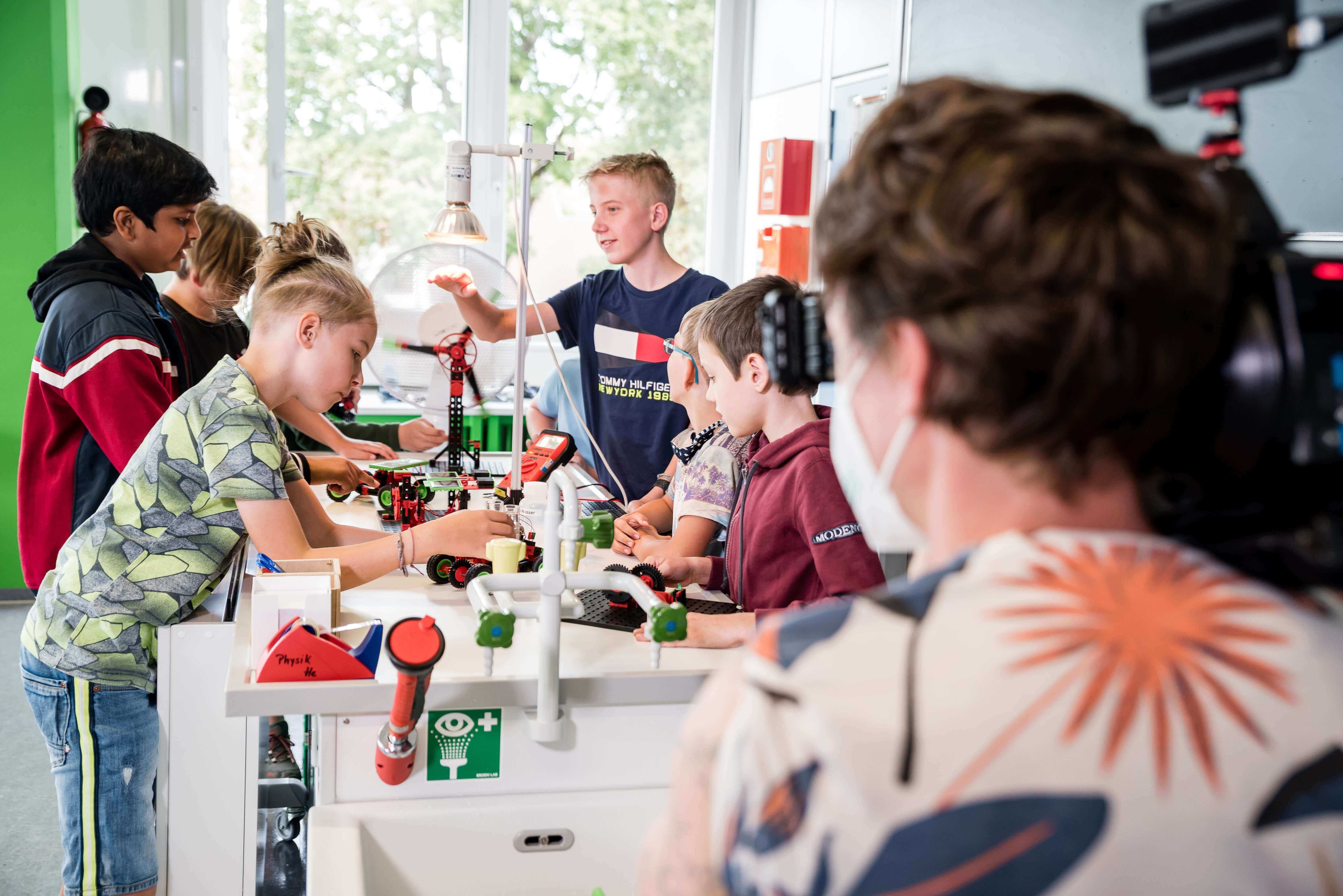 Children collaborating on a science project in a classroom, showcasing teamwork and creativity.