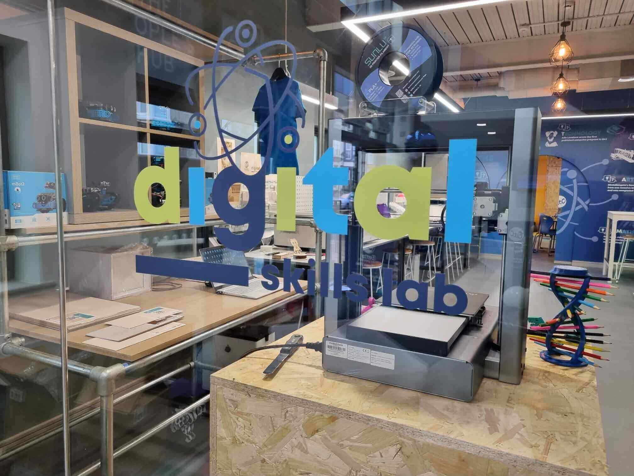 Interior view of a digital skills lab featuring a 3D printer and workspace.