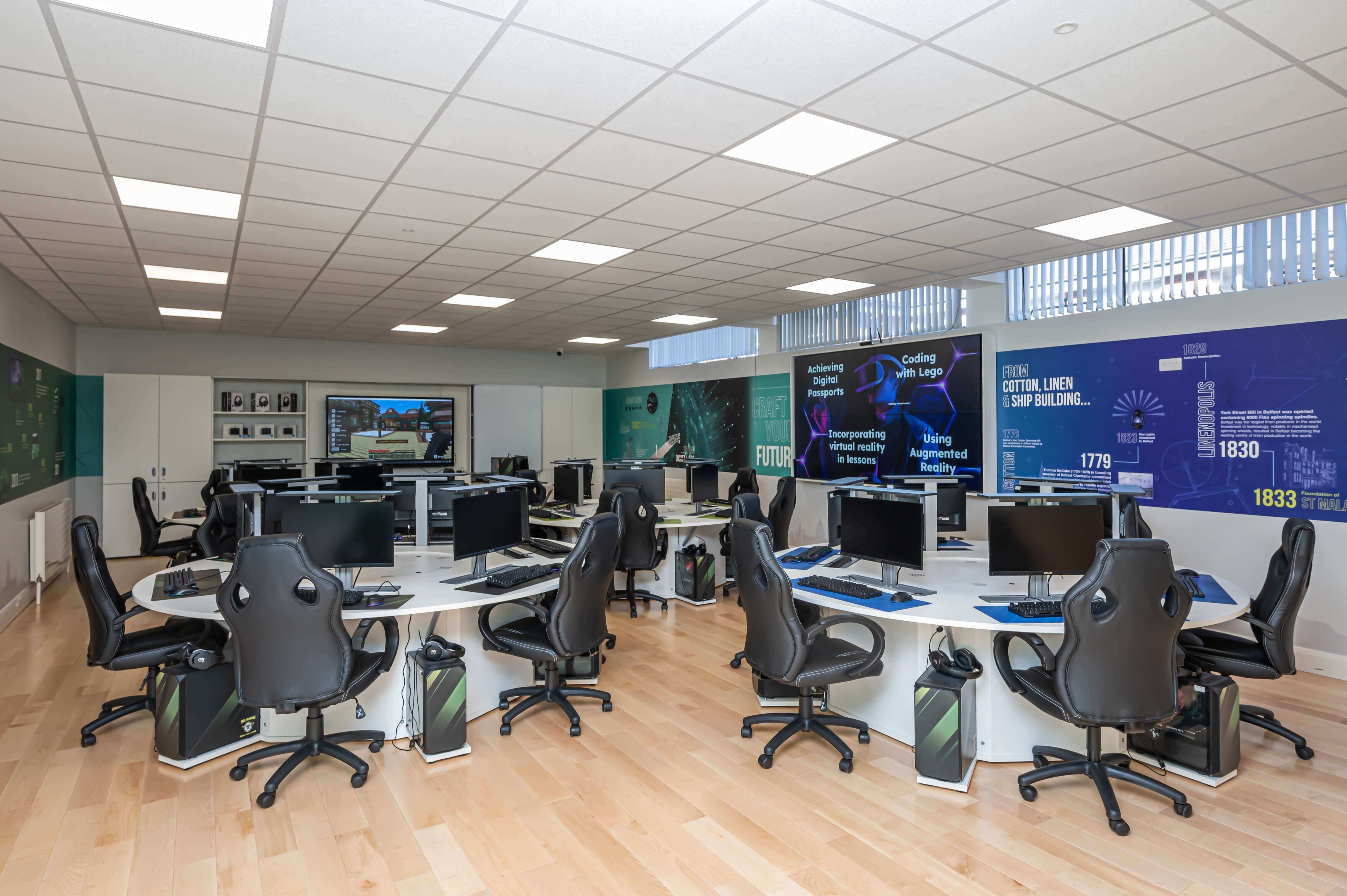 Modern office workspace with multiple computer stations and ergonomic chairs, featuring a well-lit design.
