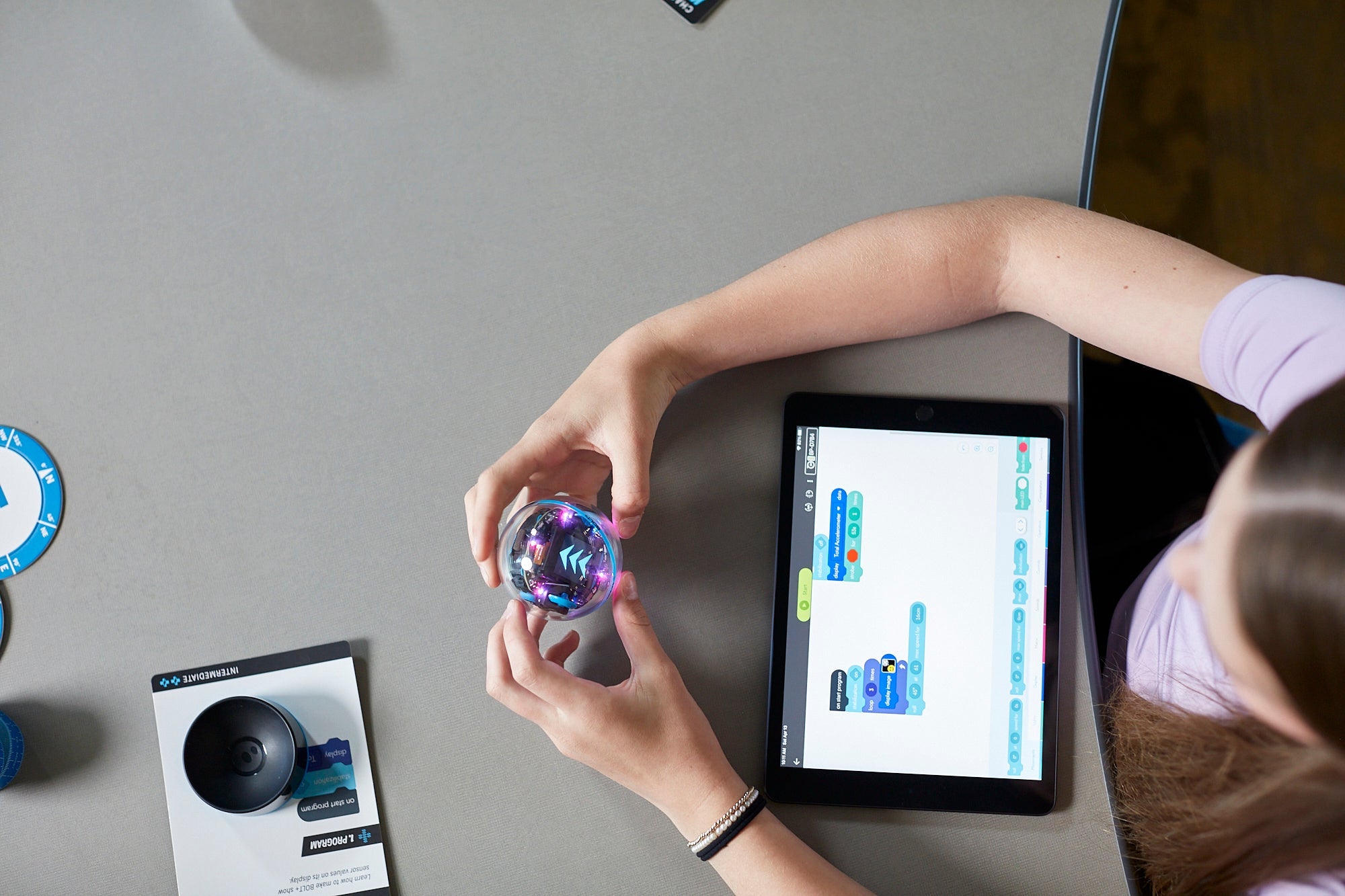 Student programming Sphero BOLT+ robot with tablet, showcasing interactive learning in education.