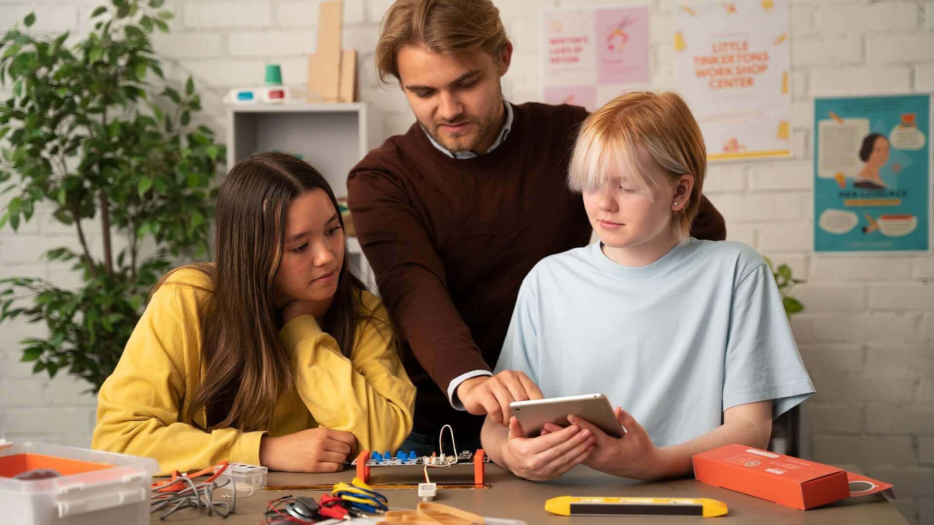 Students exploring Arduino Science Kit R3 with an instructor, engaged in hands-on learning and experiments.