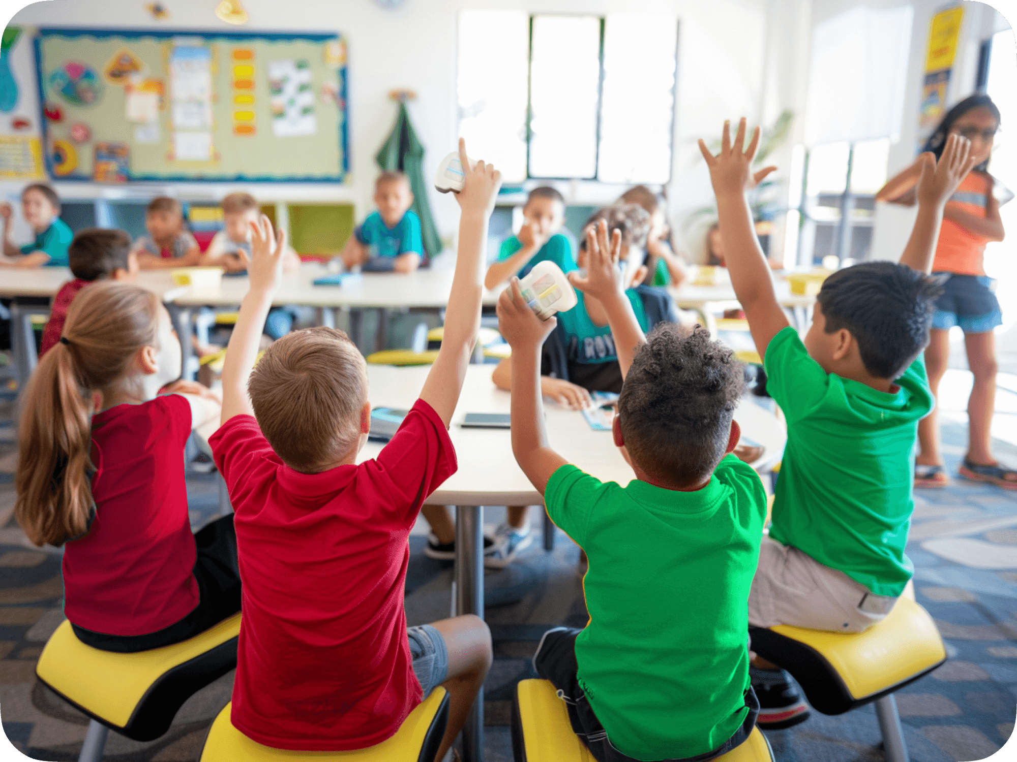 Classroom scene with students enthusiastically raising hands during an interactive learning activity.