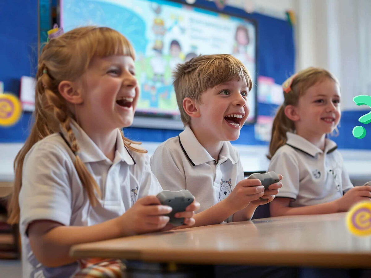 Three enthusiastic children playing video games in a classroom, smiling and engaged in learning.