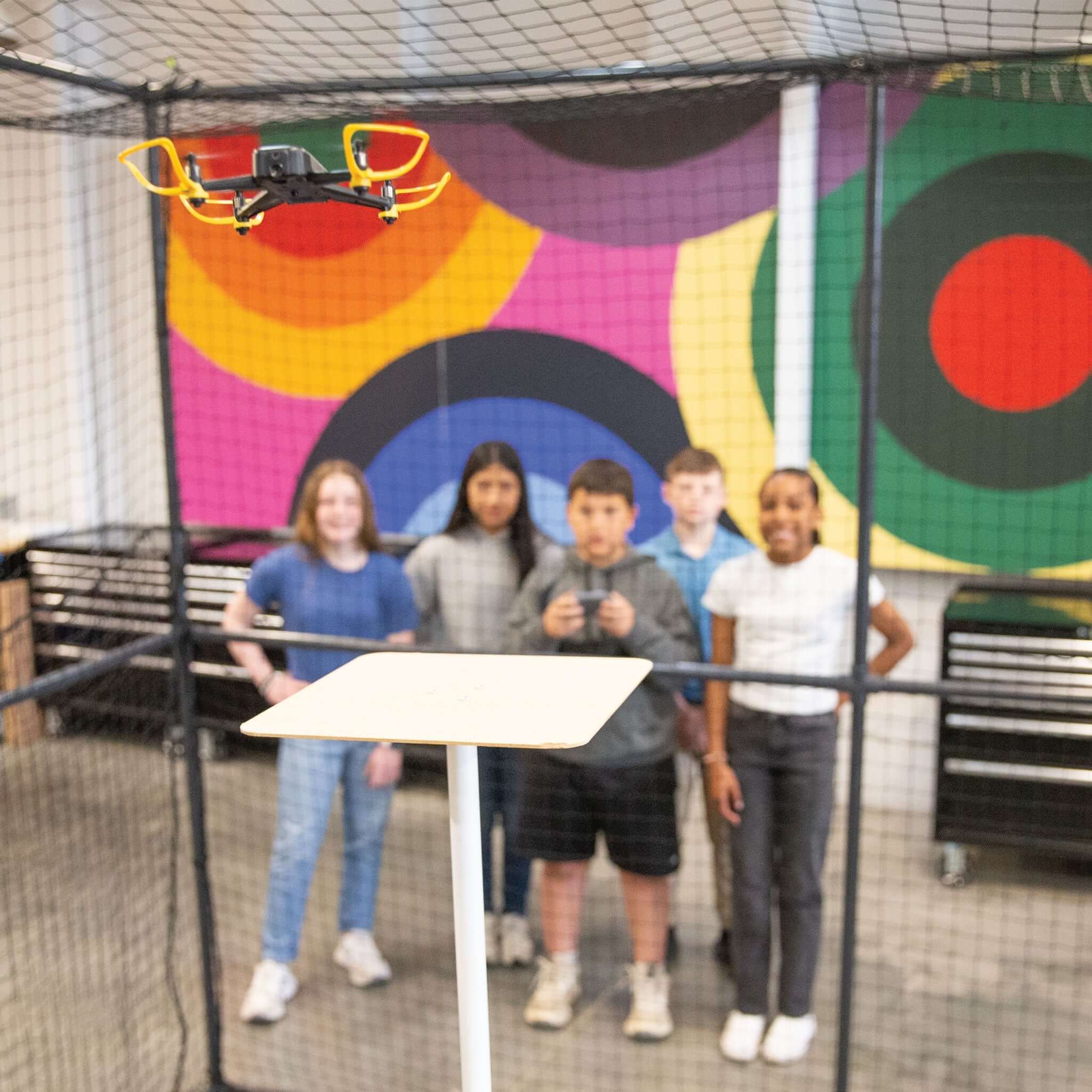 Students engaged with an Echo Drone in a colorful classroom setting, enhancing learning through aerial technology.