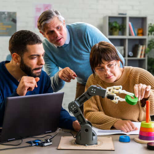 Three colleagues collaborating on a robotic arm project, analyzing components and discussing ideas in a modern workspace.