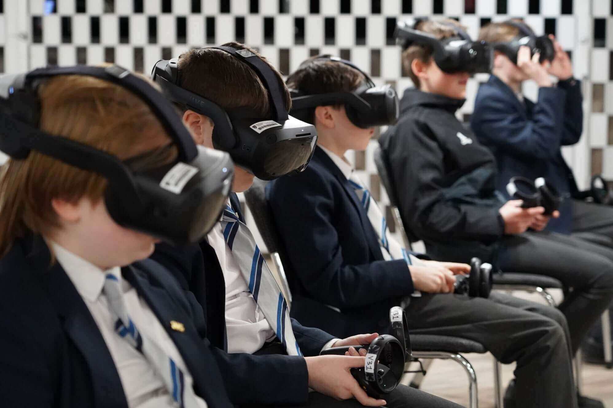 Students wearing virtual reality headsets while sitting in a classroom, engaging with technology.
