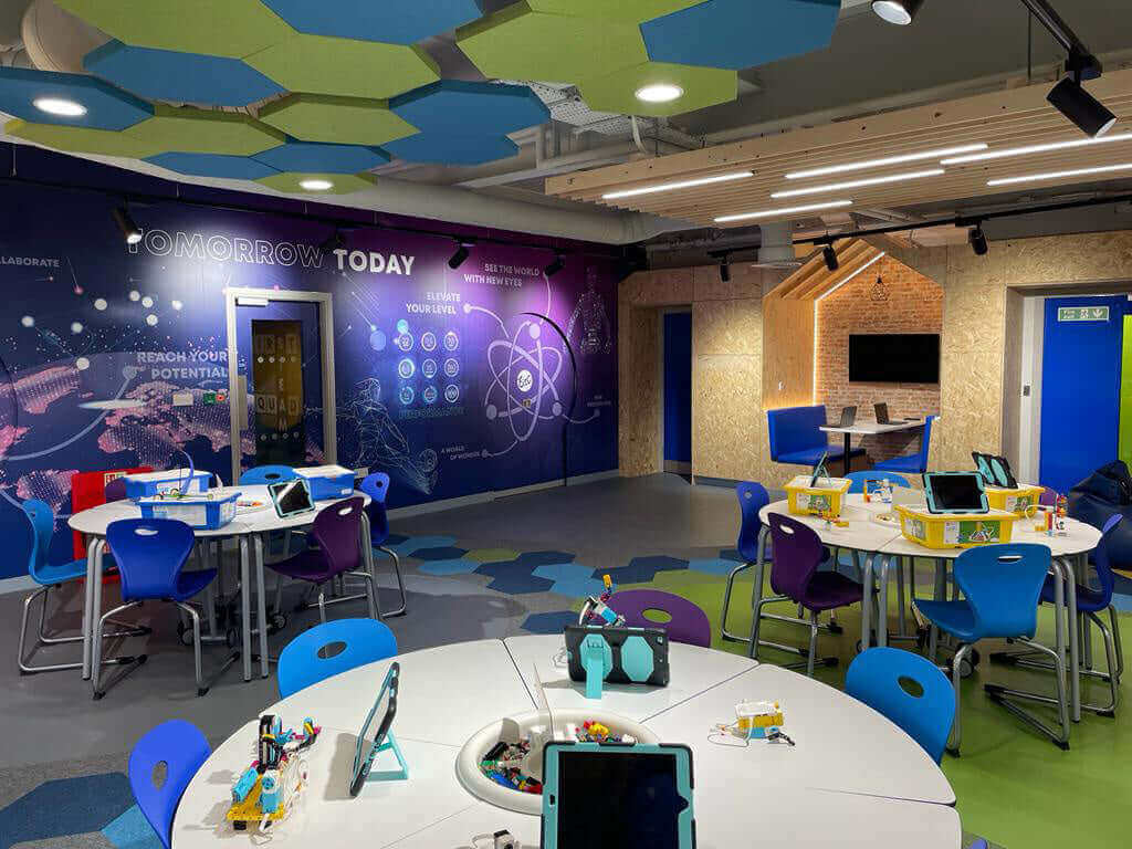 Modern learning space with colorful chairs, tables, and tech for students to explore their potential.