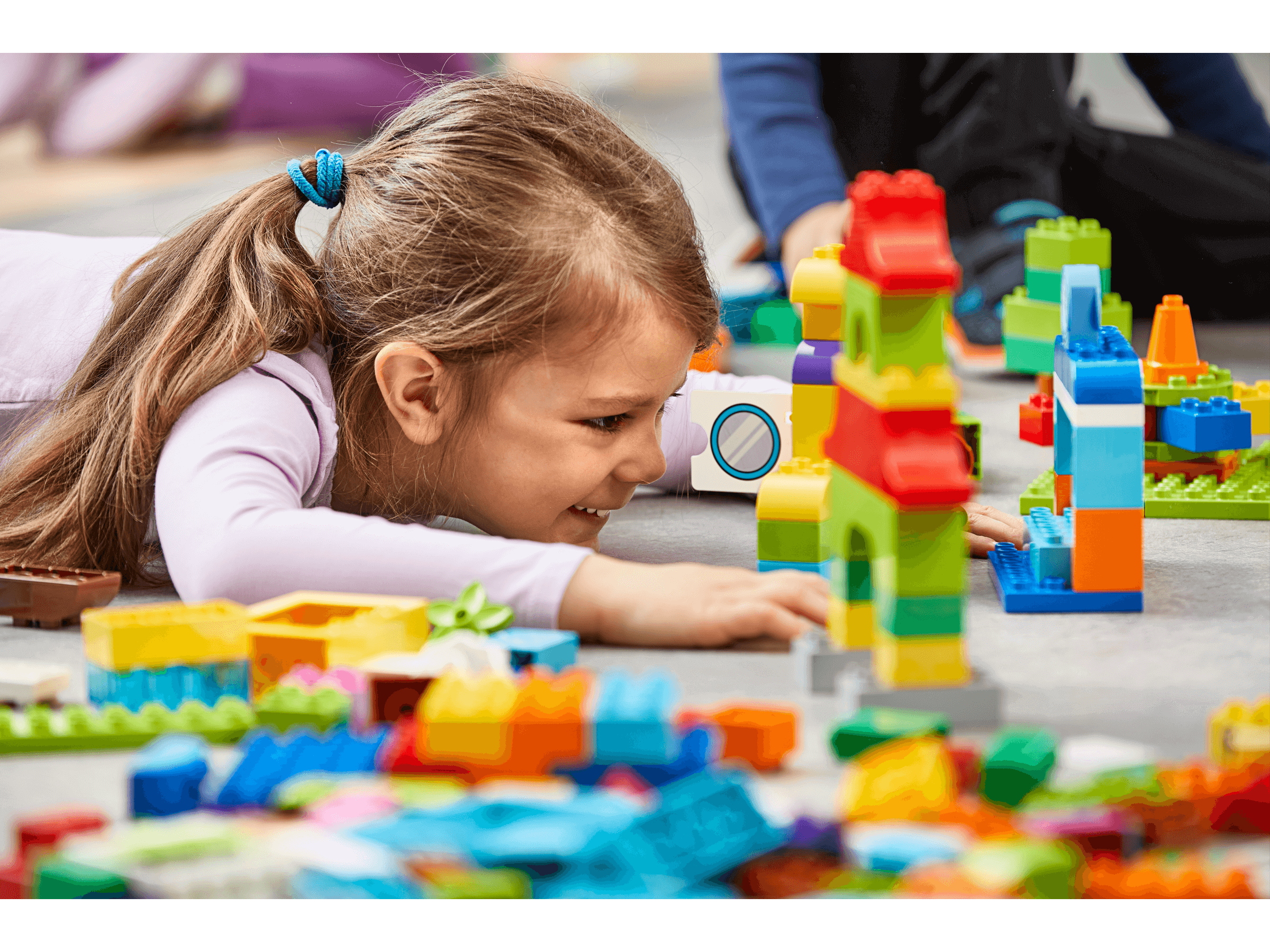 Child engaging with colorful LEGO® bricks, building and role-playing with My XL World 45028 learning set.