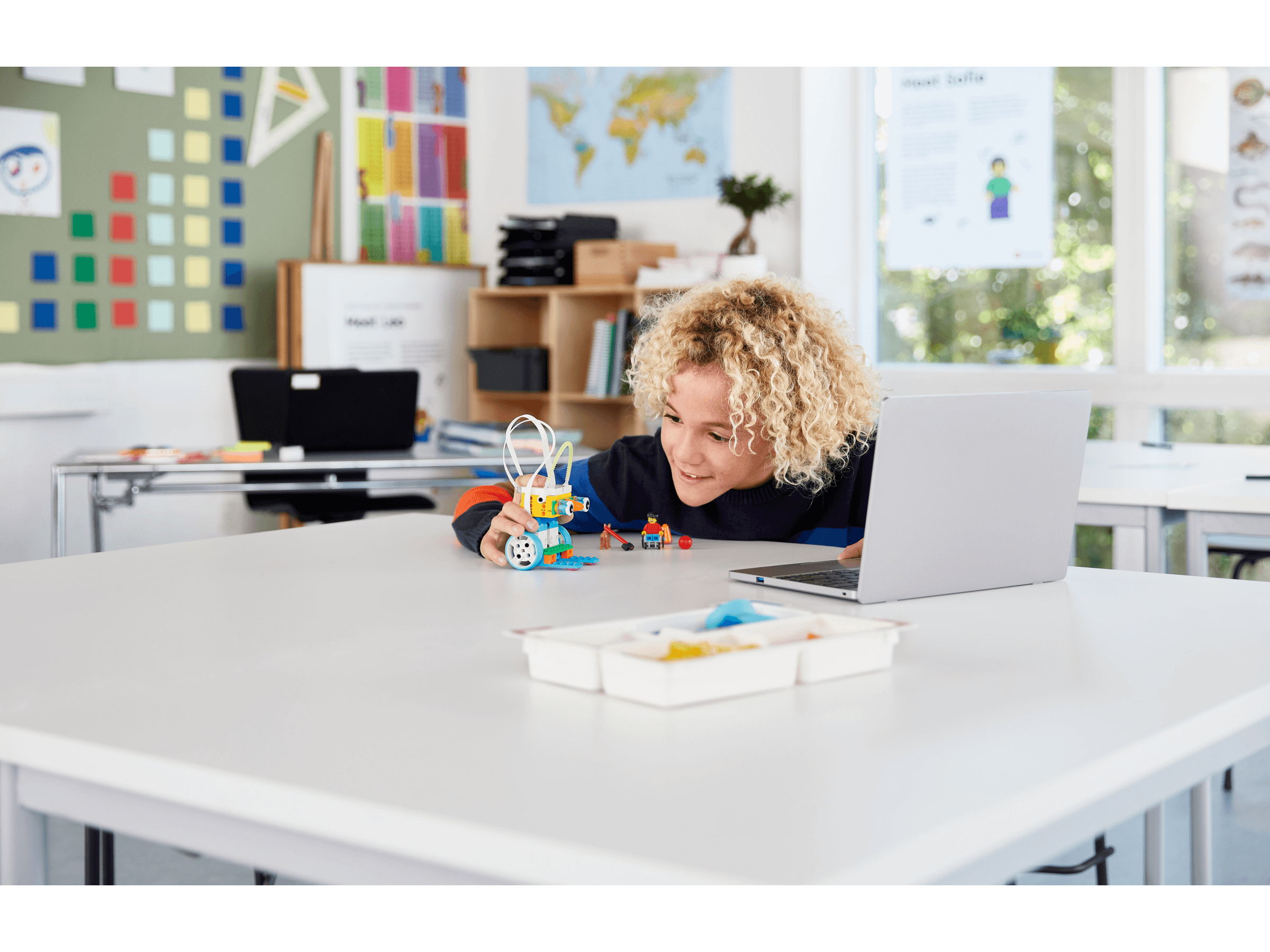 Student engaging with LEGO Education SPIKE Essential set in a classroom setting, fostering hands-on STEAM learning.