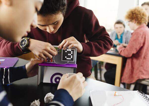 Students engaging with littleBits Code Kit, programming and creating inventions in a classroom setting.