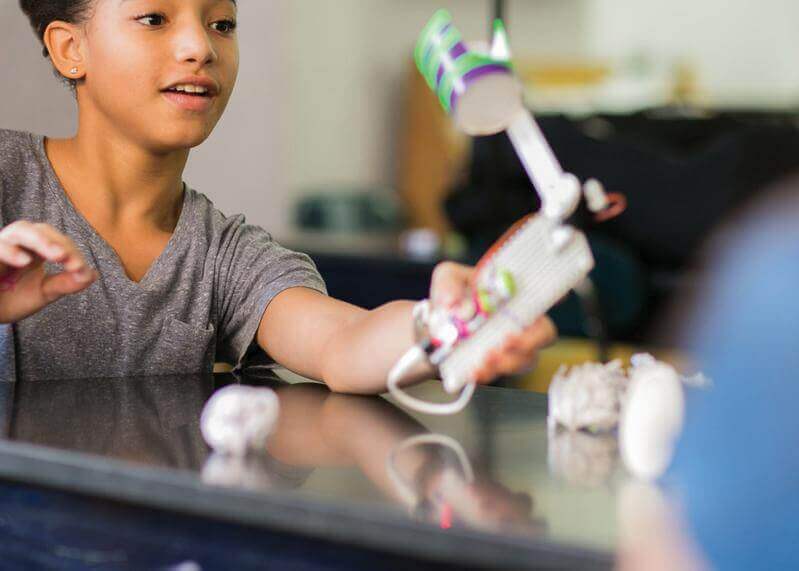 Student engaged with littleBits STEAM+ Coding Kit, showcasing creativity and engineering in a classroom setting.