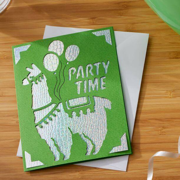 Green party-themed card featuring a llama and balloons with the text 'Party Time', displayed on a wooden table.