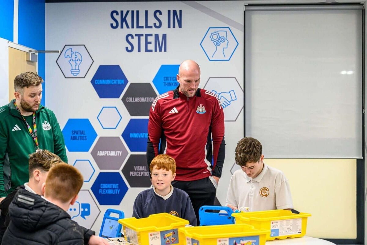 Newcastle United staff engaging with children in a STEM skills workshop using yellow containers and learning materials.