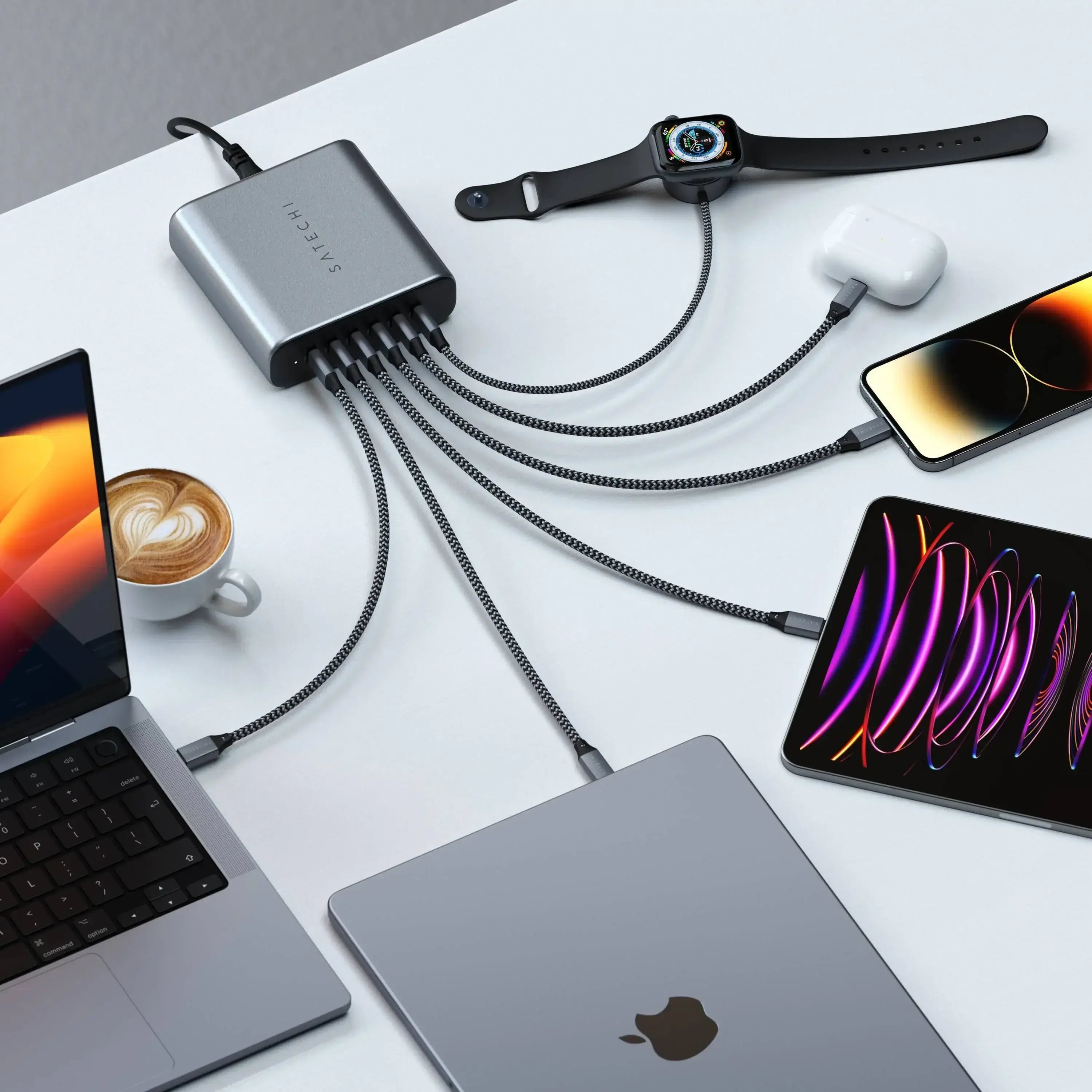 Satechi 200W USB-C GaN Charger powering multiple devices on a desk with a laptop, phone, smartwatch, and AirPods.