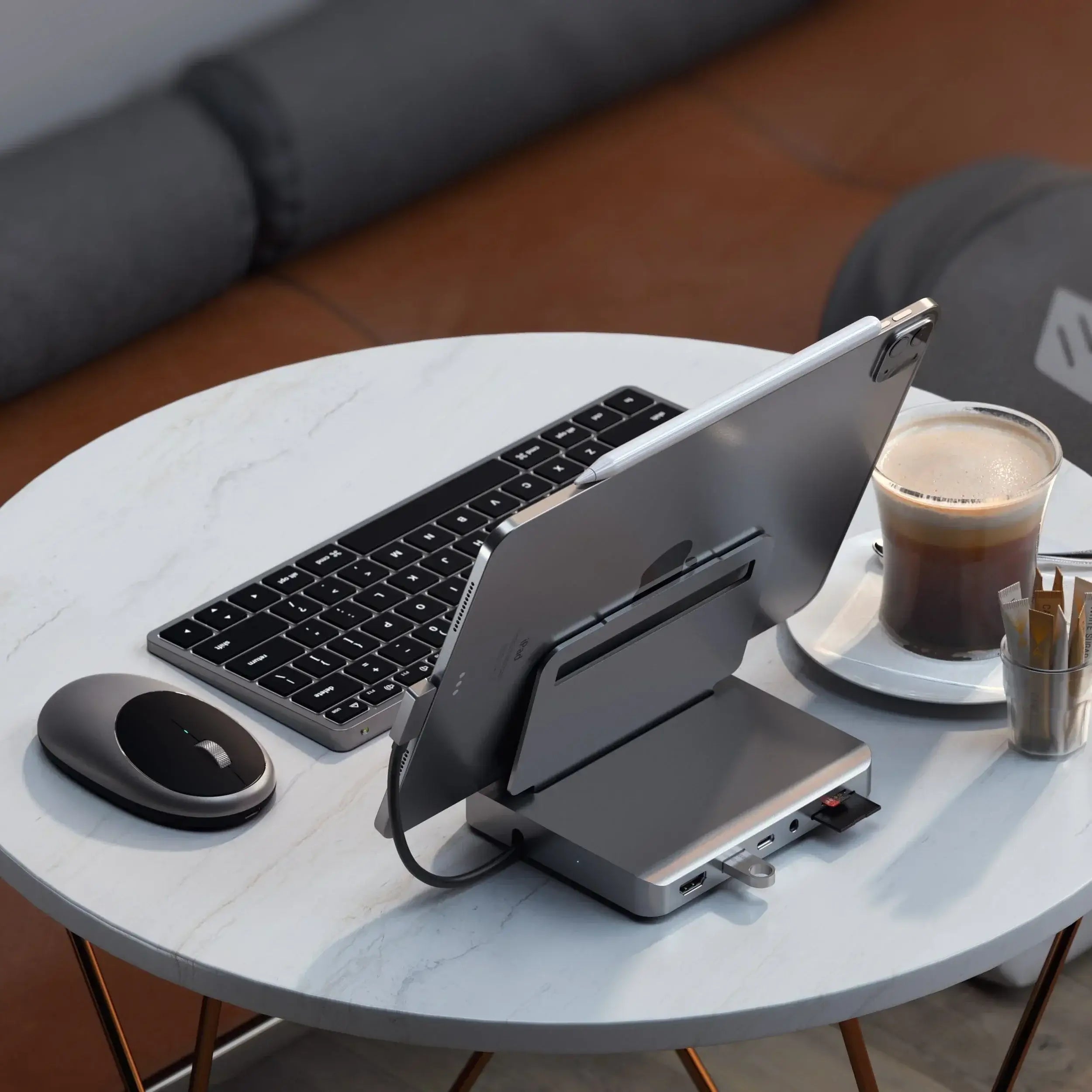 Satechi M1 Bluetooth Mouse on a table next to a tablet, wireless keyboard, and coffee, showcasing a modern workspace.
