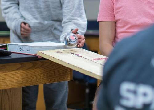 Students programming Sphero robot on a wooden ramp as part of the Computer Science Foundations course.