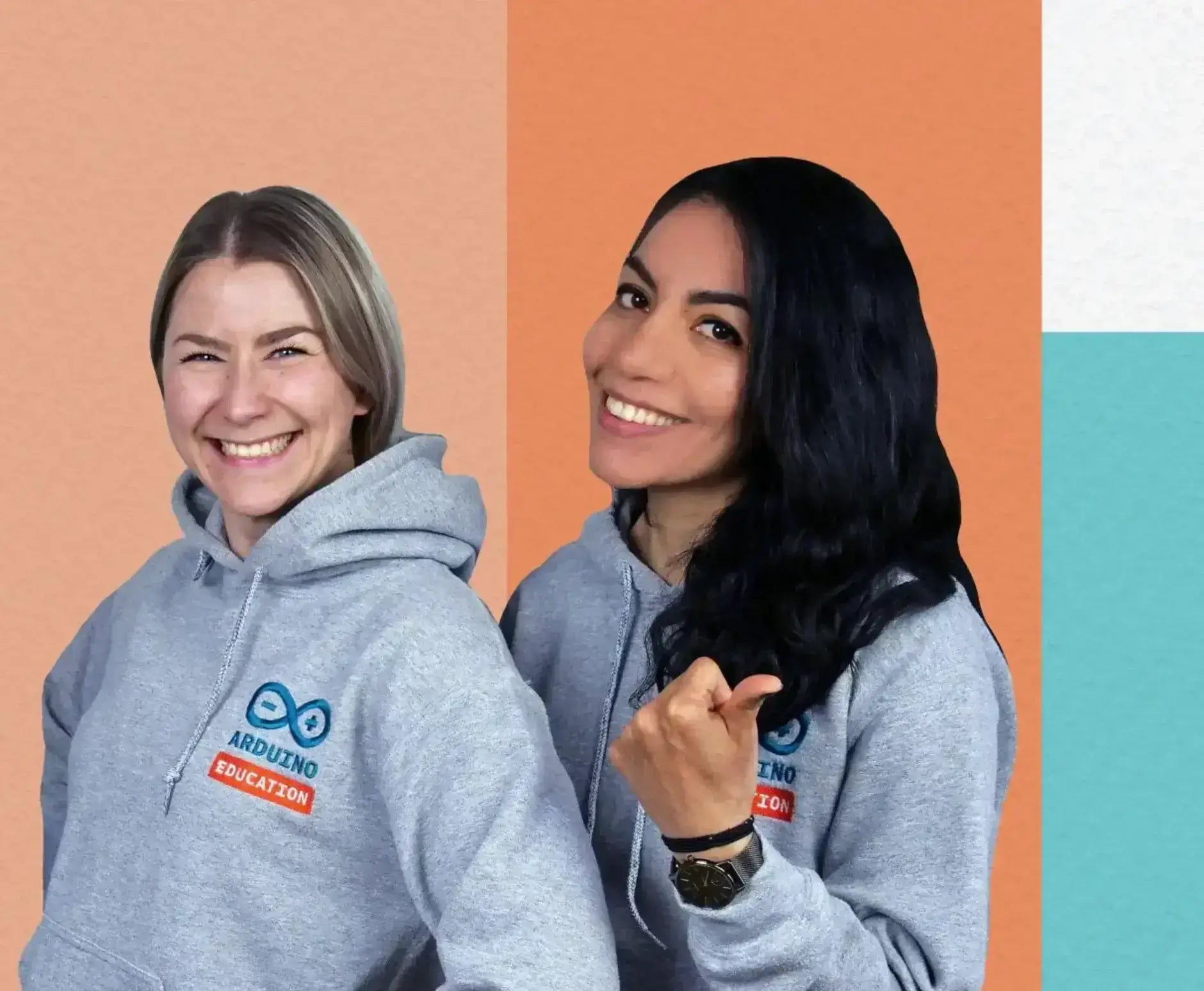 Two women smiling in gray hoodies showcasing Arduino Education, set against a colorful backdrop.