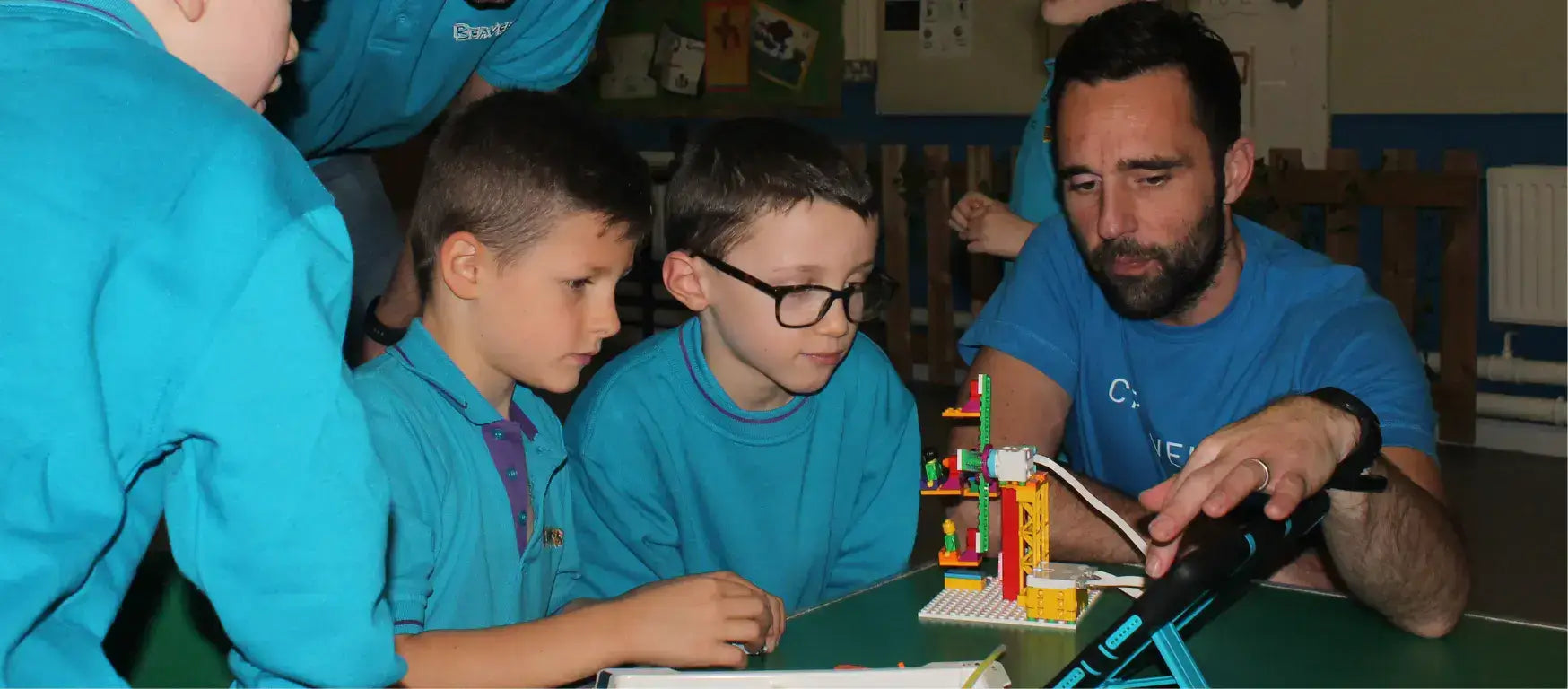 Beaver Scouts engaged in a LEGO Education SPIKE workshop with an instructor, promoting coding skills.