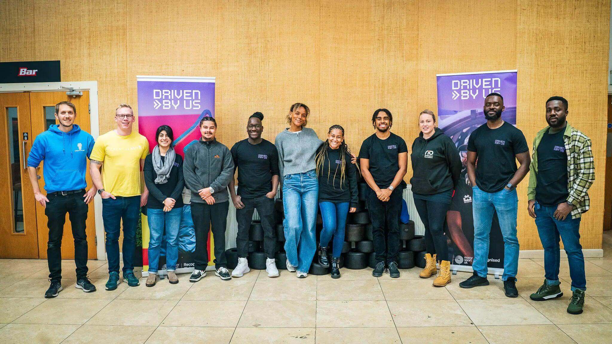 Group of diverse individuals at a robotics workshop promoting inclusion and teamwork in technology.