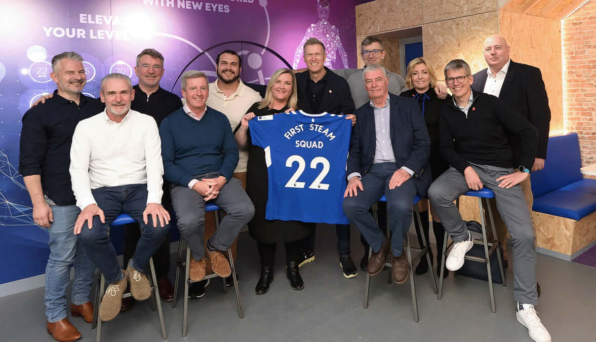 Group portrait of Everton in the Community team holding a jersey, promoting a Digital Skills Lab in Merseyside.