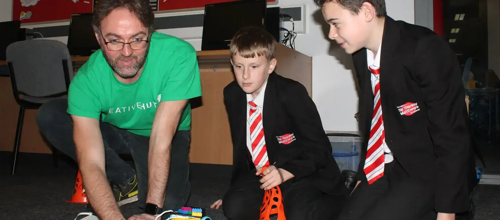 Participants at Ormiston Academy STEAM Workshop engaging with robotics and technology in an educational environment.