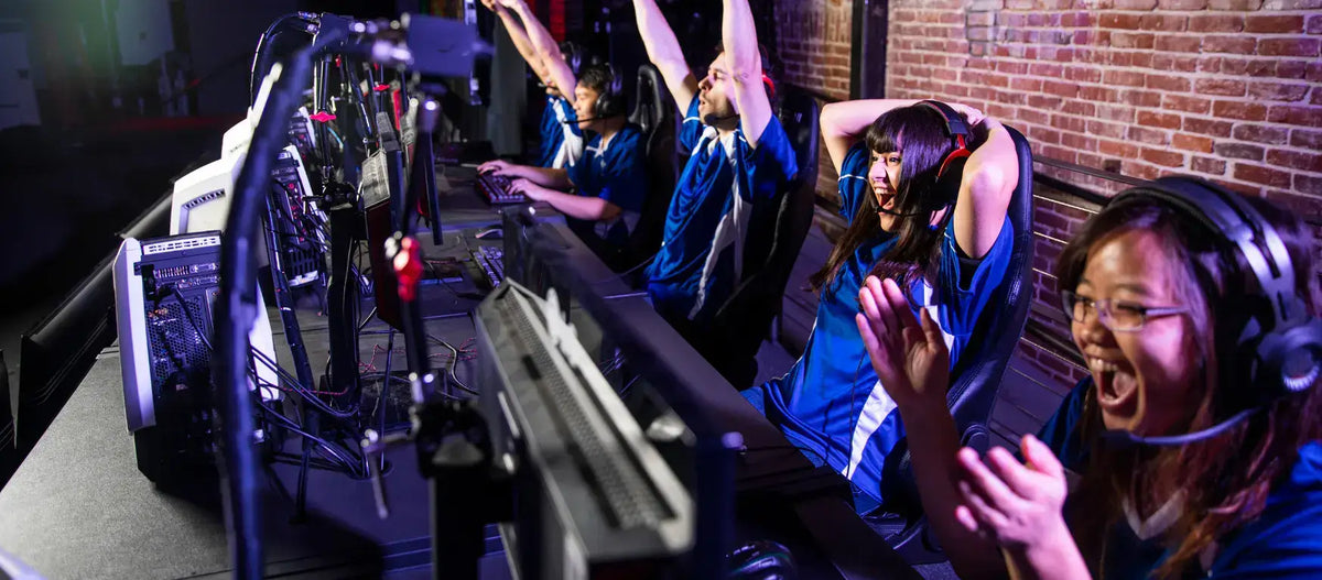 Excited esports players celebrating victory during a gaming tournament in a modern venue.