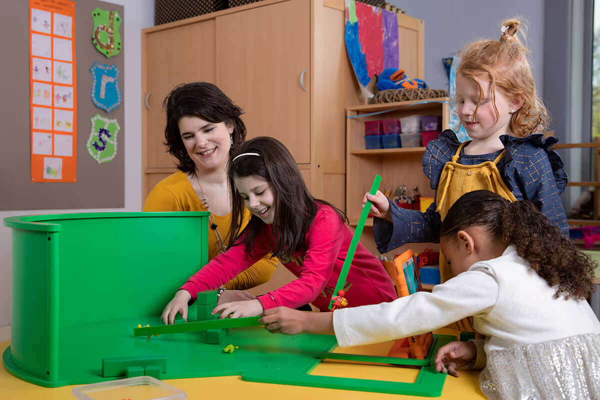 Children and teacher engaged in creative play with colorful educational toys in a bright classroom setting.