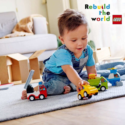 Toddler playing with LEGO® DUPLO My First Car Creations set featuring colorful trucks and cars on a play mat.
