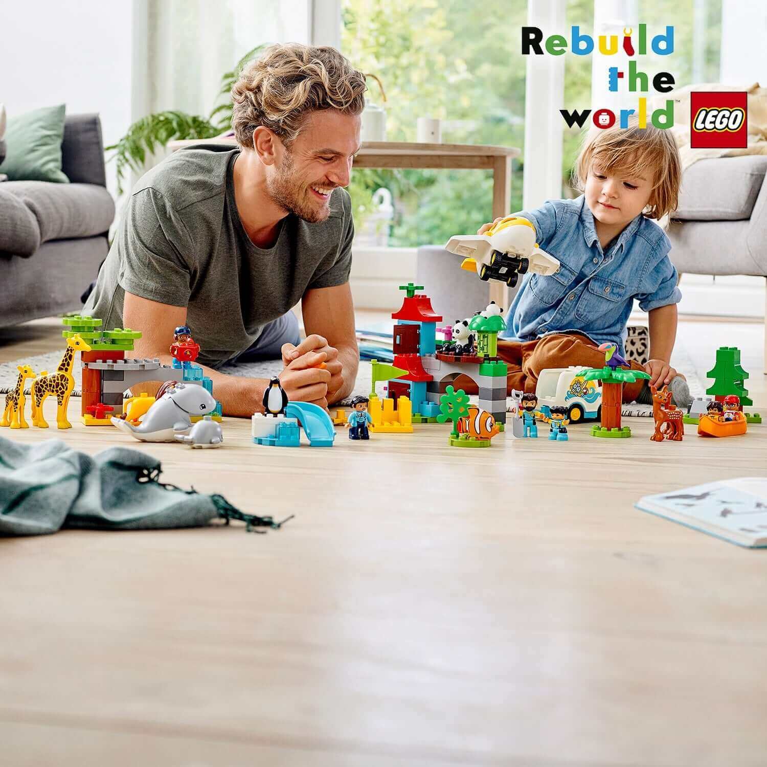 Parent and child playing with LEGO® DUPLO Town World Animals set, featuring animals and colorful buildable environments.