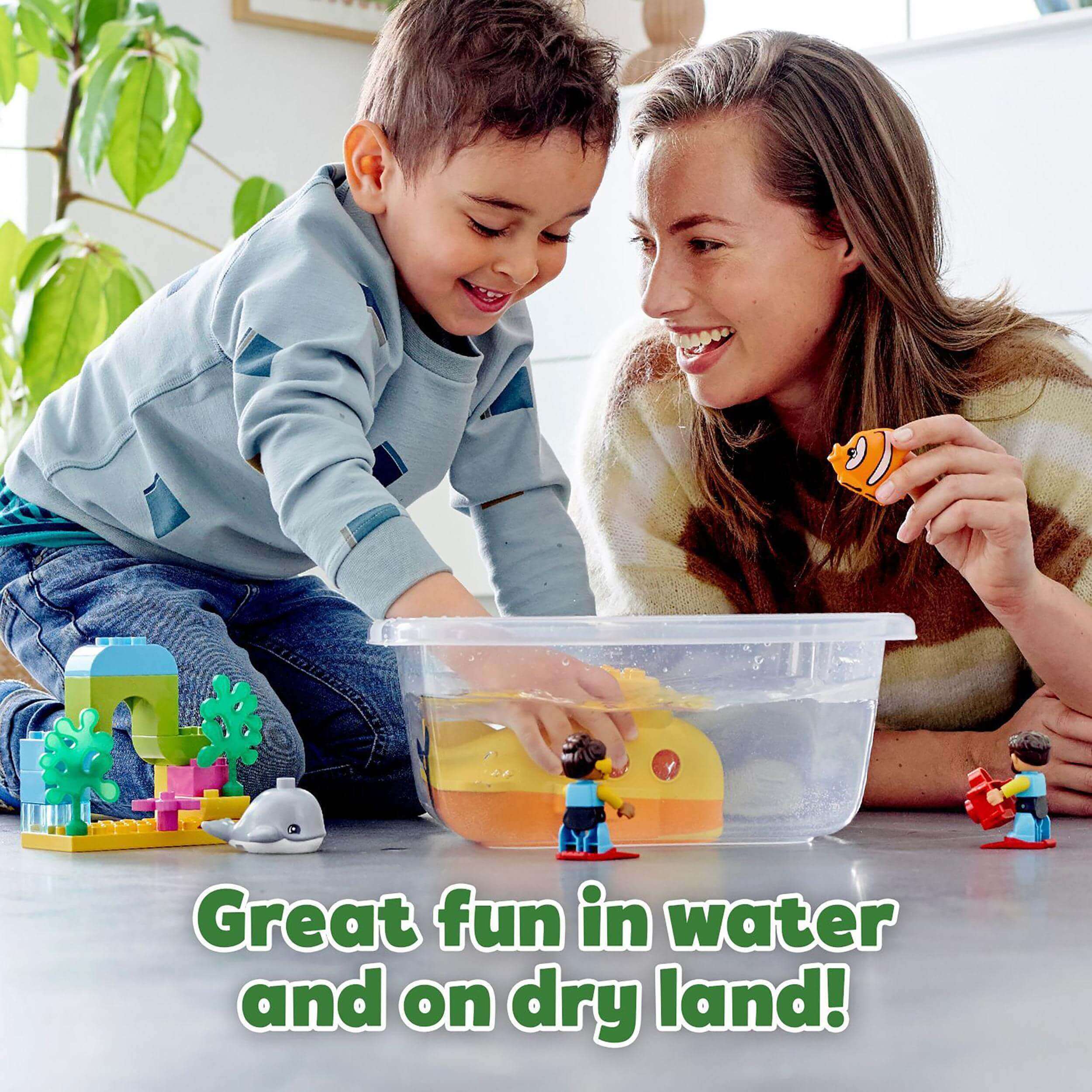 A toddler and a parent play with the LEGO® DUPLO Town Submarine Adventure bath toy, enjoying fun in and out of water.