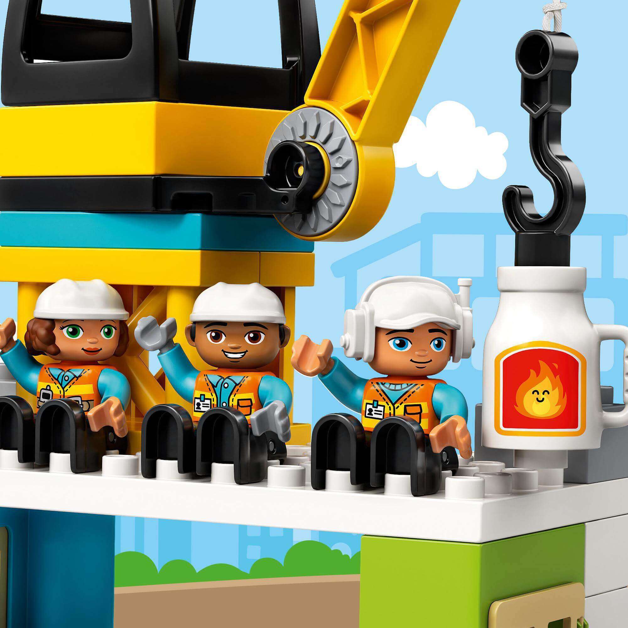 LEGO DUPLO Town Tower Crane set with three construction worker figurines at a busy construction site.