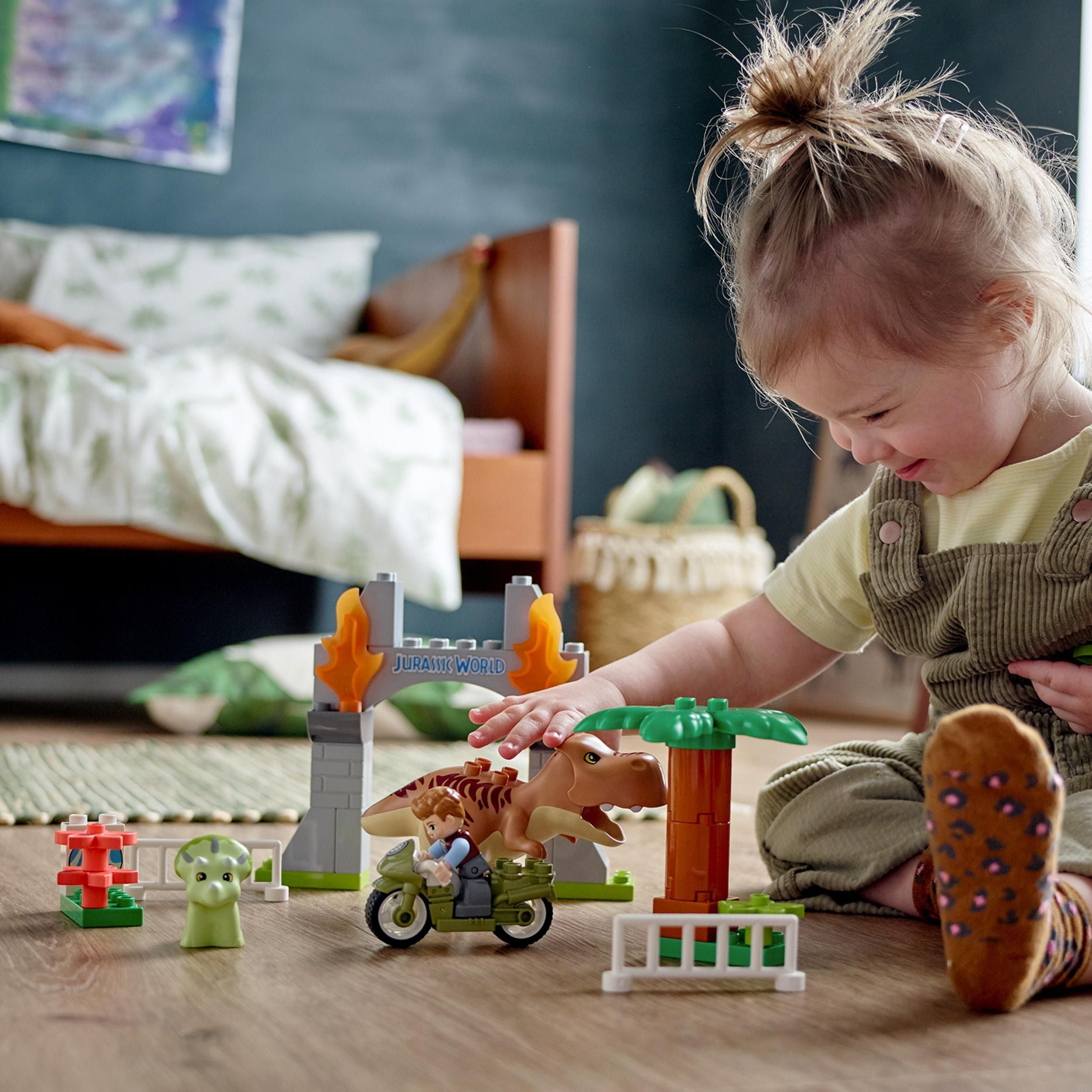 Child playing with LEGO® DUPLO T. rex and Triceratops dinosaur toy set, sparking imagination in Jurassic World.