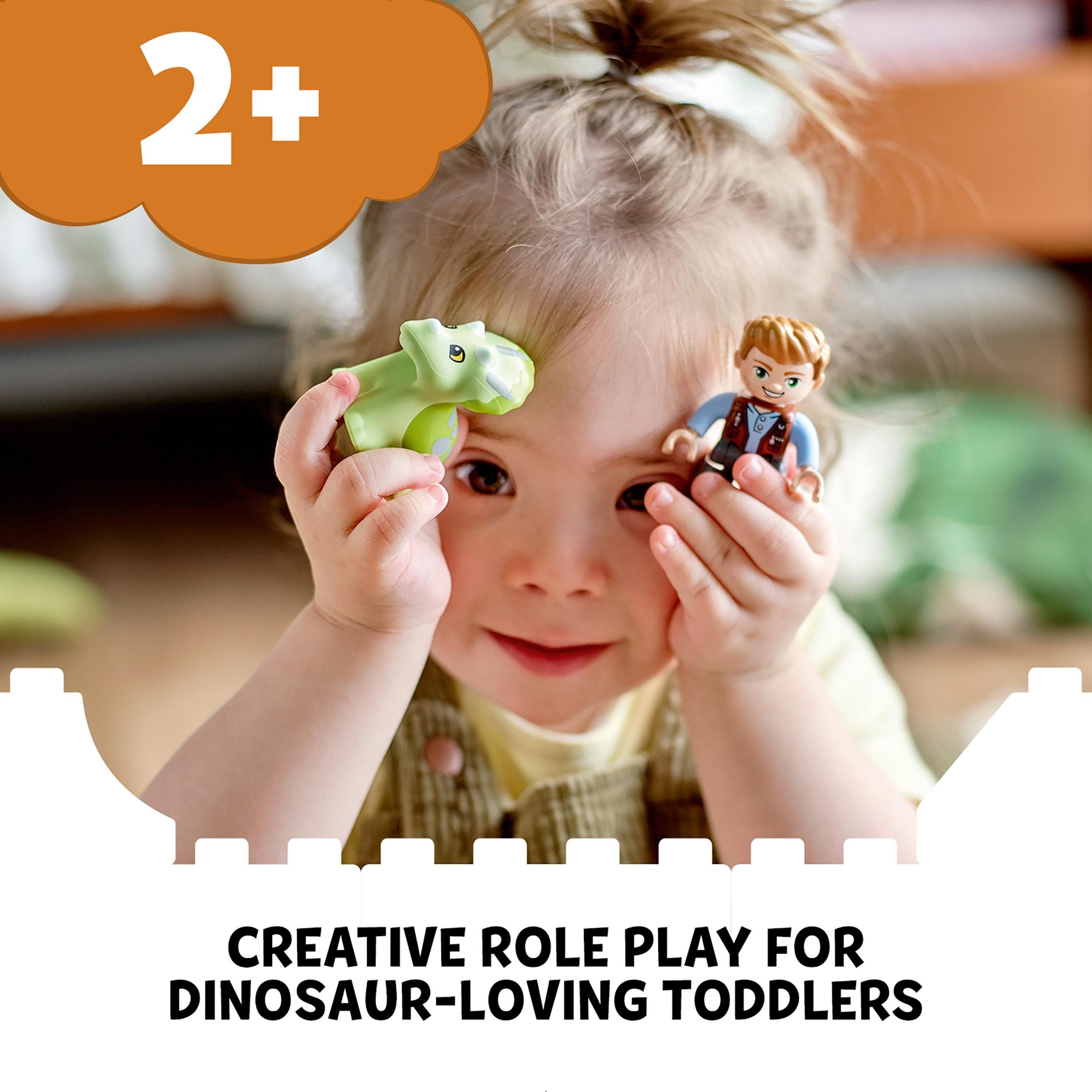 Toddler engaging in creative role play with LEGO® DUPLO dinosaur toy, perfect for dinosaur-loving kids aged 2 and up.