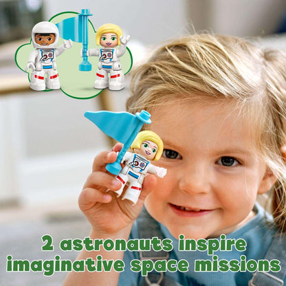 Toddler with LEGO DUPLO astronauts holding a blue flag, sparking imaginative space missions and development skills.