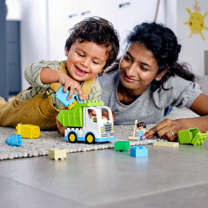 Child and parent playing with LEGO® DUPLO Town Garbage Truck & Recycling Toy 10945, promoting learning about recycling.