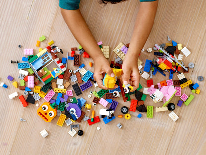 A child playing with colorful LEGO bricks and pieces from the LEGO Classic 11003 Bricks and Eyes set.