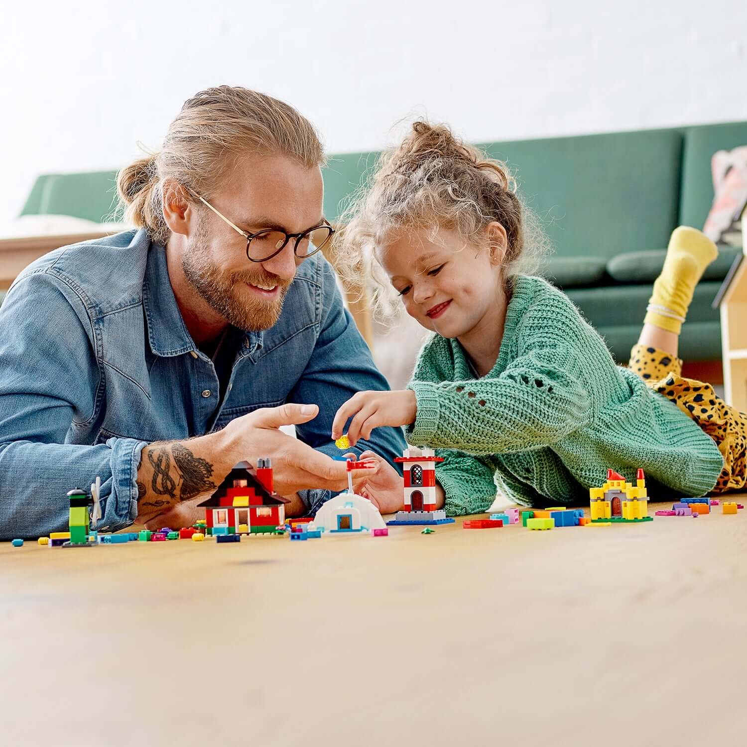 Father and daughter building colorful LEGO houses together, enjoying creative playtime with LEGO Classic 4+ Bricks and Houses set.