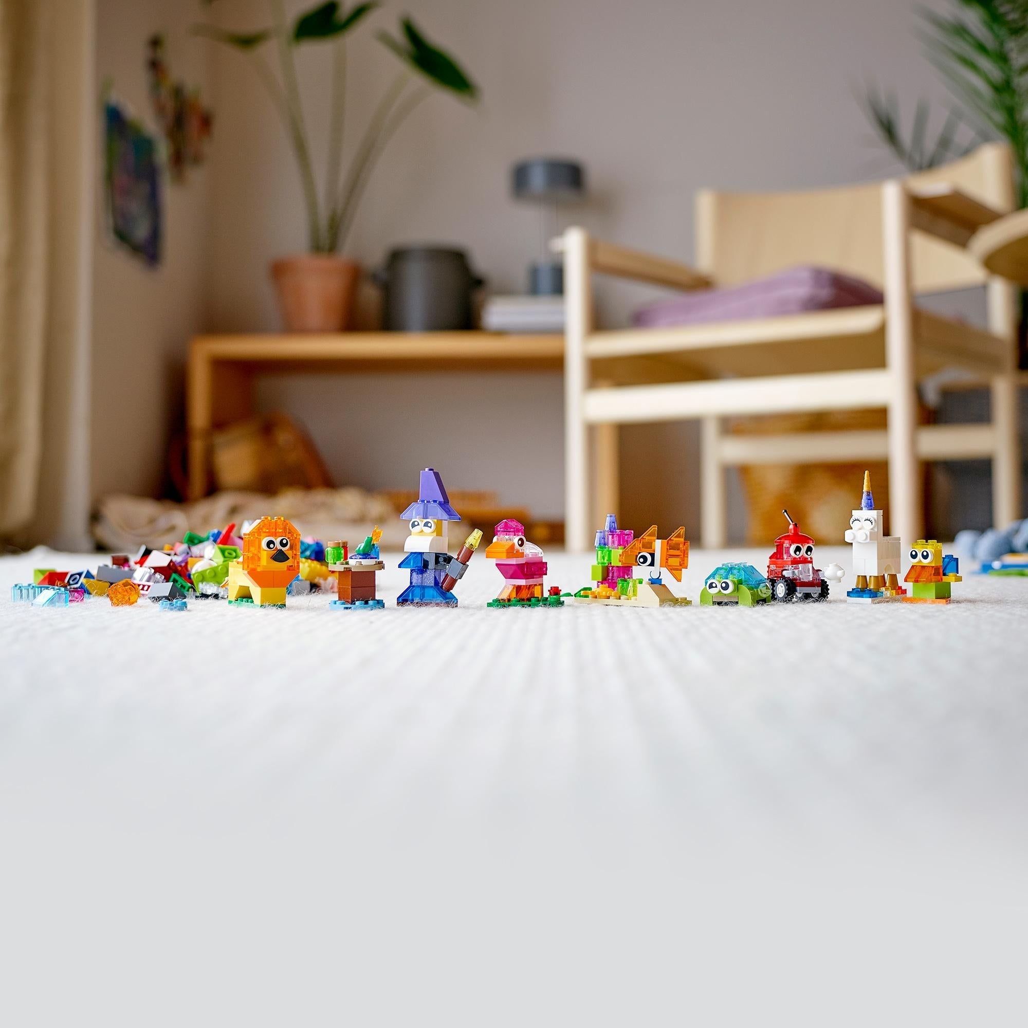Colorful LEGO® creations showcased on the floor, featuring various fun models made with transparent bricks.