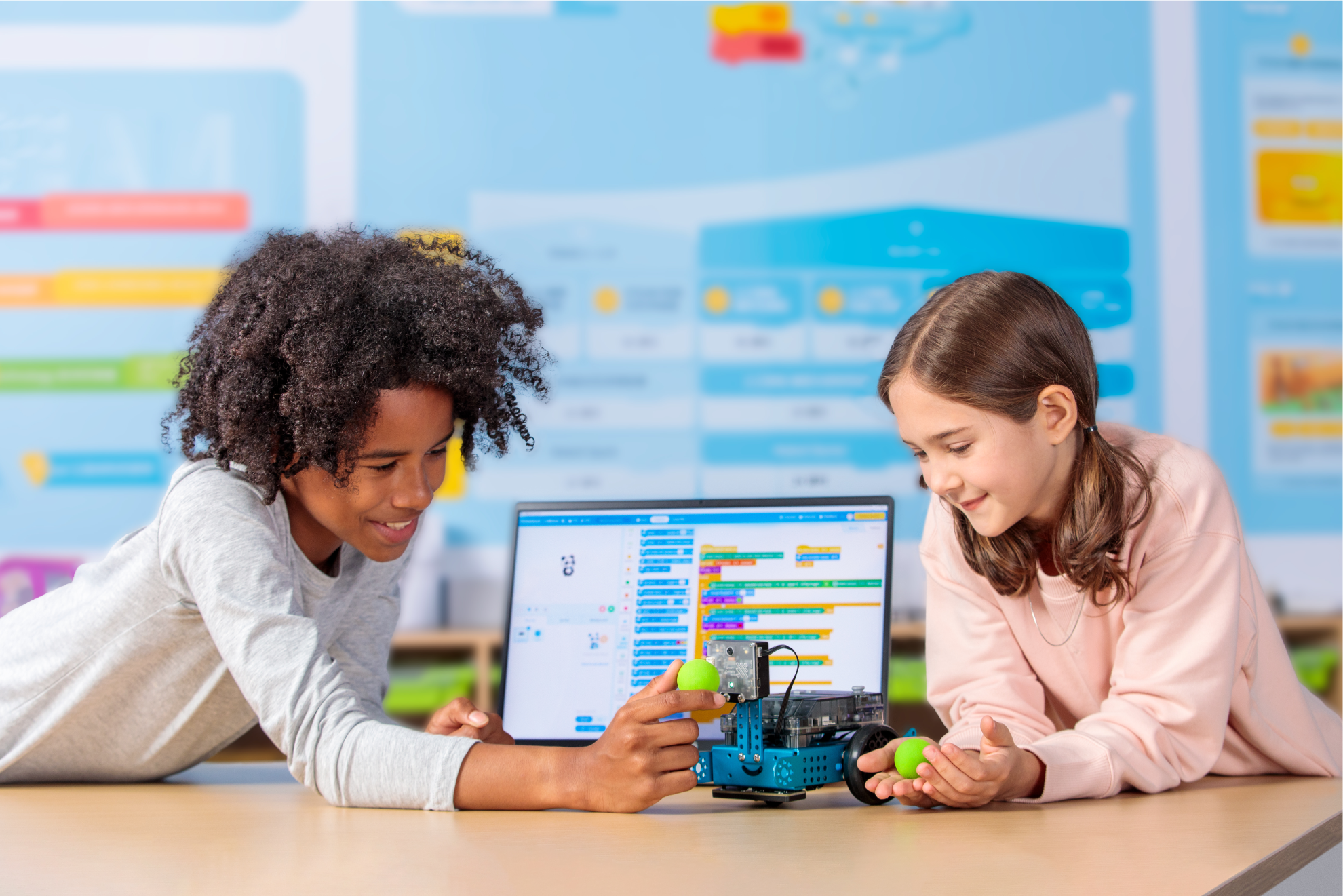 Two children engaging with Makeblock mBot 2 educational robot and programming interface in a learning environment.