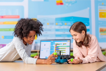 Two children engaging with Makeblock mBot 2 educational robot and programming interface in a learning environment.