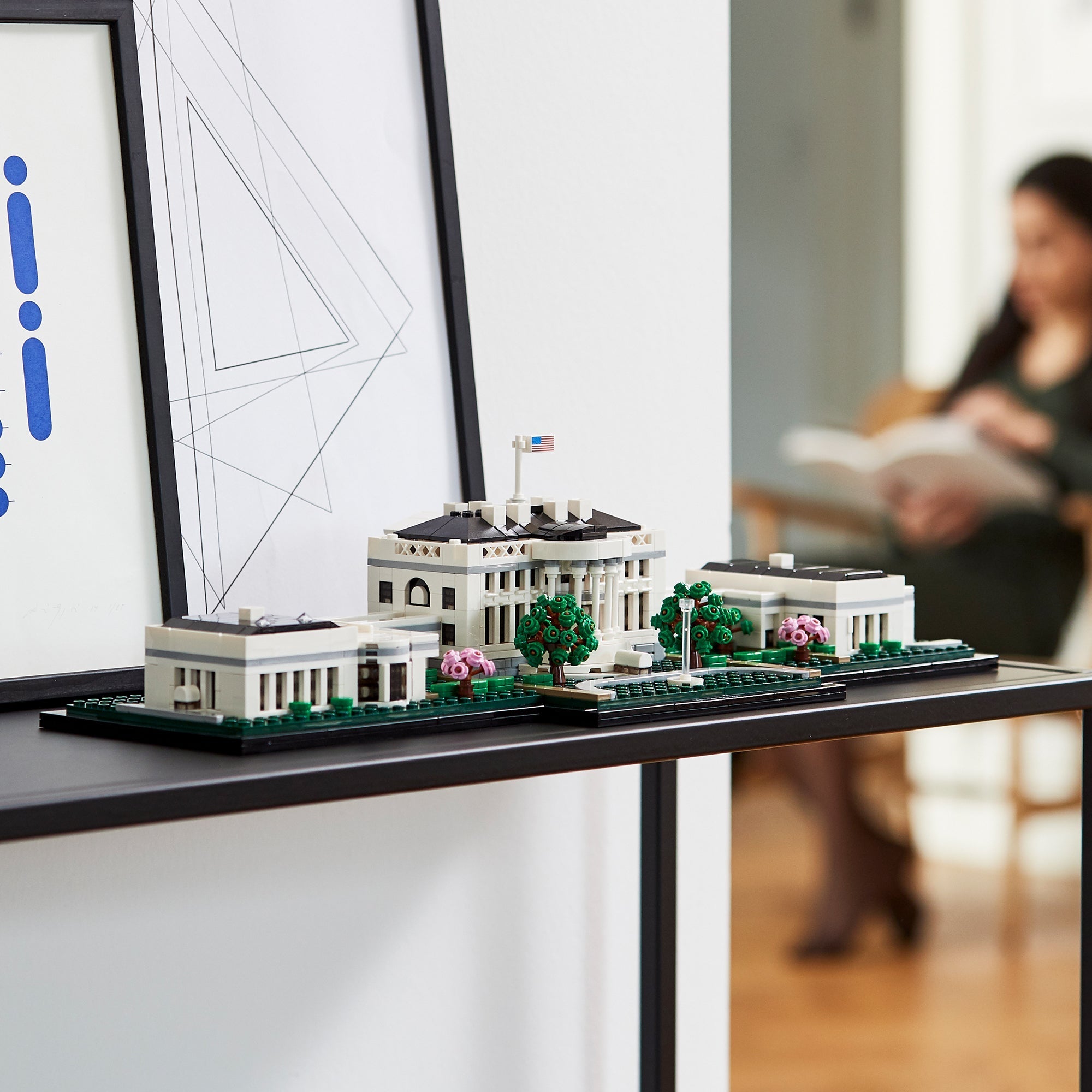 LEGO Architecture The White House Building Set 21054 displayed on a modern shelf, featuring detailed bricks and greenery.