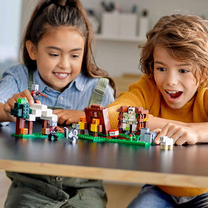 Kids playing with LEGO® Minecraft The Pillager Outpost Set 21159 featuring Iron Golem and Pillager figures.