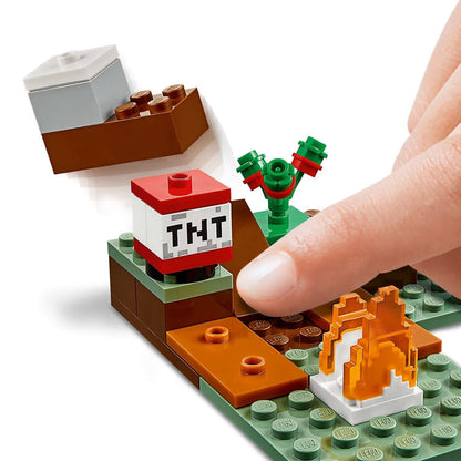 Close-up of LEGO® Minecraft set with TNT block and player's hand interacting with the build.